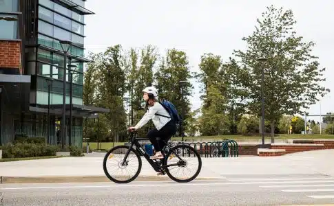 man in white shirt riding bicycle on road during daytime