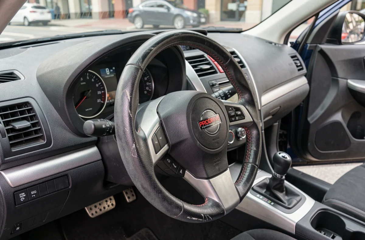 Tableau de bord et badge PRODRIVE sur le volant d'une Subaru WRX d'occasion lors d'une inspection intérieure détaillée
