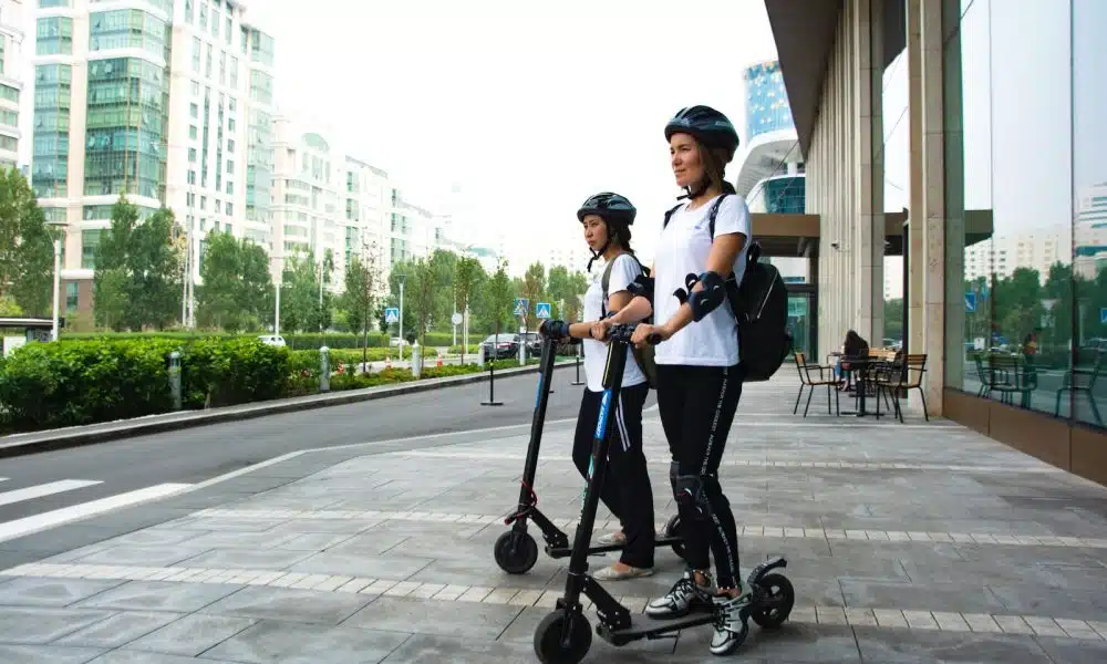 two women riding kick scooters