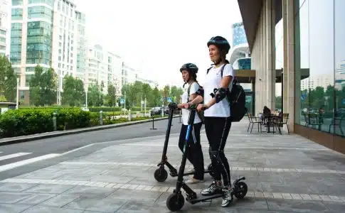 two women riding kick scooters